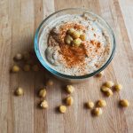 glass bowl of hummus with paprika and chickpeas on top