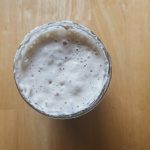 bubbling sourdough starter in a glass jar