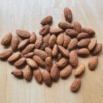 almonds in a pile on a wood table