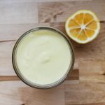 homemade mayonnaise in a glass jar with a lemon next to it
