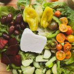 greek inspired salad with block of feta on top