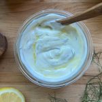 glass bowl of healthy homemade tzatziki sauce on a wooden surface