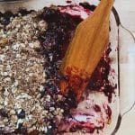 homemade blueberry crisp with a wooden spatula being served