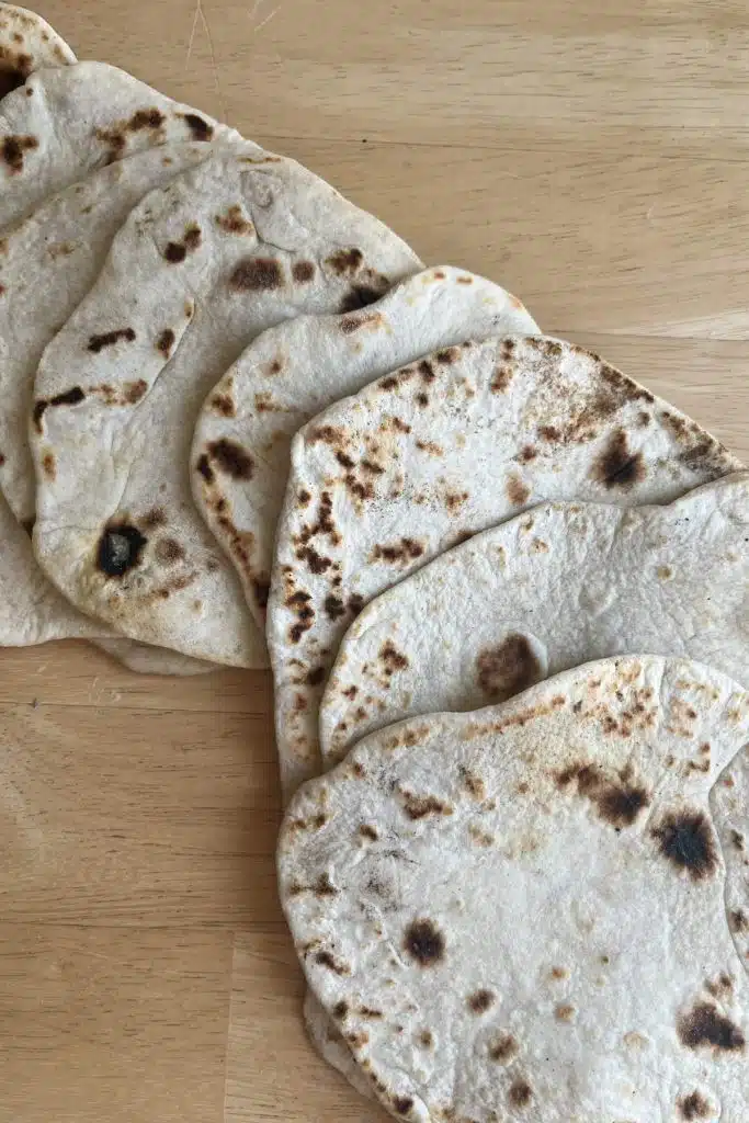 sourdough tortillas laid out on a wood surface